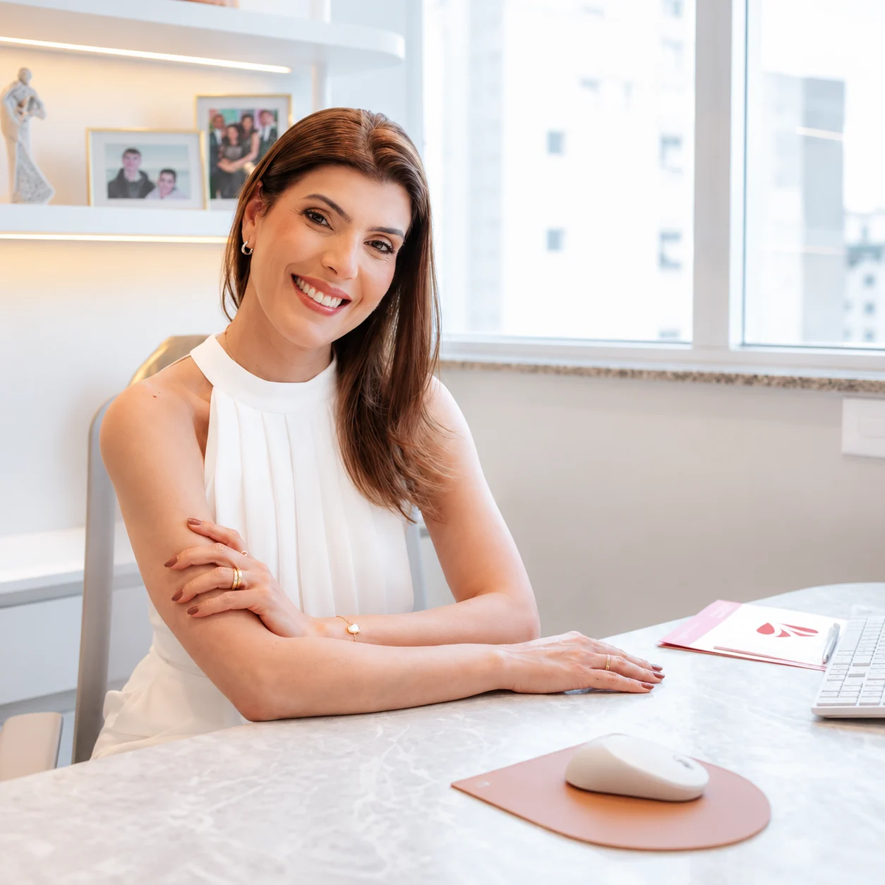 Dra. Marina Mariz sorrindo à mesa do consultório